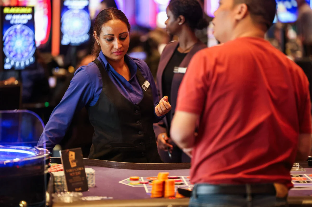 Palms table games dealer assisting a guest at a gaming table